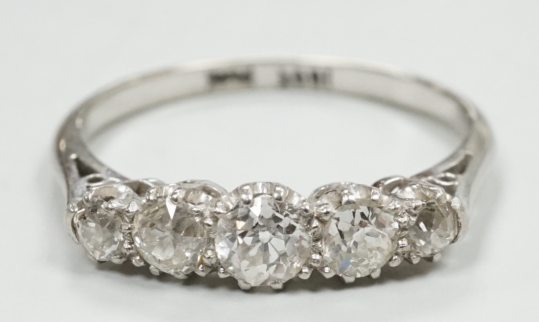 A mid 20th century 18ct, plat and graduated five stone diamond set half hoop ring, size Q, gross weight 3 grams.
